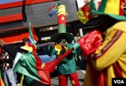 Para pendukung Kamerun meniupkan instrumen khas Afrika Selatan, 'vuvuzela,' di depan Stadion Free State di Bloemfontein.