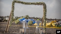 Wreaths and floral installations stand next to piles of wreckage where an Ethiopian Airlines Boeing 737 Max 8 crashed shortly after takeoff on Sunday, killing all 157 on board.