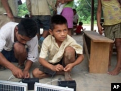 Boys help assemble an LED system