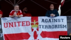 Manchester United fans hang a banner in reference to the terror attack in Manchester before a match.