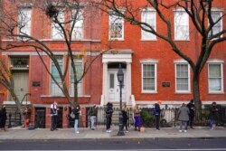 Pedestrians wait in line to get tested for COVID-19 at a mobile testing site near the NYU campus in New York, Dec. 16, 2021.