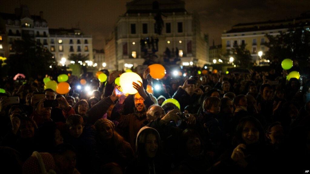 People hold illuminated balloons as they gather to mark Earth Hour in Madrid, March 25, 2017. Earth Hour is marked around the world, with millions expected turn out the lights to raise awareness about climate change.