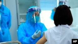 Một nhân viên y tế được tiêm vắc xin AstraZeneca.