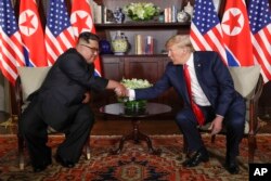 North Korea leader Kim Jong Un and U.S. President Donald Trump during their first meeting at the Capella resort on Sentosa Island Tuesday, June 12, 2018 in Singapore. (AP Photo/Evan Vucci)