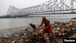A man cleans garbage along the banks of the river Ganges in Kolkata, India, April 9, 2017. 