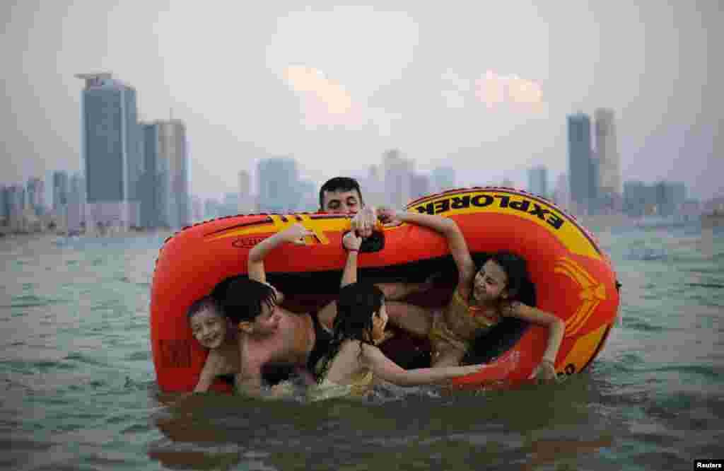 A man plays with his family at Mamzar beach in Dubai, United Arab Emirates.