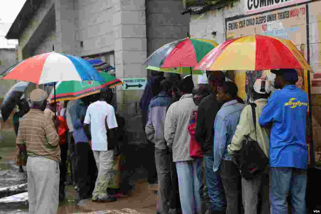 Des Zambiens bravent de fortes pluies saisonnières afin de voter au Chawama canton, Lusaka, le 20 janvier 2015. (Gillian Parker / VOA)