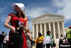 Una mujer vestida con un traje inspirado en la novela The Handsmaid's Tale de Margaret Atwood, acompaña una protesta contra leyes antiaborto aprobadas recientemente en varios estados de EE.UU. Washington, mayo 21 de 2019.