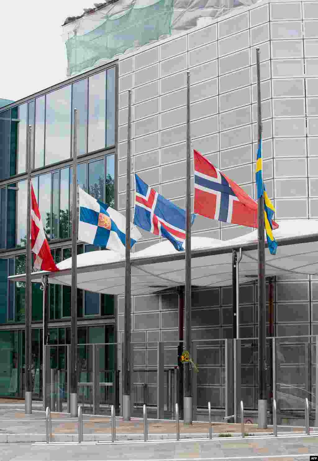 The flags of Scandinavian countries fly at half-staff in front of the Scandinavian and Nordic Embassies' building in Berlin, Germany, Saturday July 23, 2011. A Norwegian is reported to have set off an explosion in Oslo city centre before going on a shooti