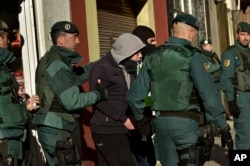 FILE - A unidentified Moroccan leaves a tea shop detained by the Spanish Civil Guard in Pamplona, northern Spain, Dec.1, 2015. Spanish authorities alleged the man was a member of a cell that recruited fighters for the Islamic State group in Syria.