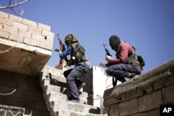 FILE - Fighters from the Kurdistan Workers' Party, or PKK, run as they attack Turkish security forces in Nusaydin, Turkey, March 1, 2016.