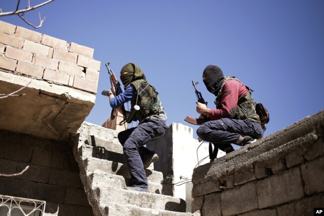 FILE - Fighters from the Kurdistan Workers' Party, or PKK, run as they attack Turkish security forces in Nusaydin, Turkey, March 1, 2016.