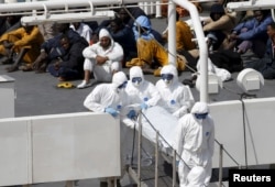 Personel Angkatan Bersenjata Malta dengan pakaian pelindung membawa jenazah imigran dari kapal penjaga pantai Italia Bruno Gregoretti di Grand Harbour Valletta, 20 April 2015. (Foto: Reuters)