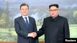 FILE - South Korean President Moon Jae-in shakes hands with North Korean leader Kim Jong Un during their summit at the truce village of Panmunjom, North Korea, May 26, 2018.