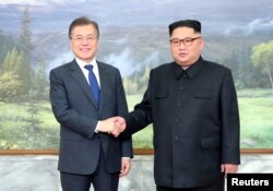 South Korean President Moon Jae-in shakes hands with North Korean leader Kim Jong Un during their summit at the truce village of Panmunjom, North Korea, May 26, 2018.