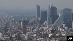 Haze hangs over Mexico City at midday, March 15, 2016. The Mexico City government declared its first air pollution alert in 11 years Monday after ozone levels reached almost twice the acceptable limit.