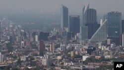 FILE - Haze hangs over Mexico City. Some two billion children live in regions where outdoor air pollution exceeds WHO's minimum air quality guidelines.