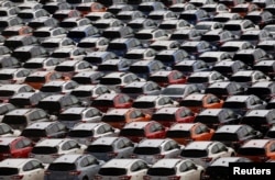 FILE - Newly manufactured cars await export in a port in Yokohama, Japan, May 30, 2017.