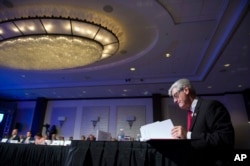 Mississippi Gov. Phil Bryant looks over documents during the opening session of the National Governors Association Winter Meeting in Washington, Feb. 25, 2017.