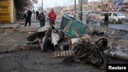 Residents inspect the site of a bomb attack in Baghdad, Jan. 14, 2014. 