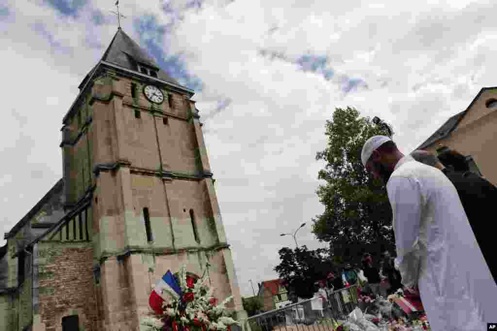 Muslim worshipers hold a minute of silence in front of the memorial at the Saint Etienne church in Saint-Etienne-du-Rouvray, Normandy, France. Four days after the hostage-taking in the town, officials and worshipers of the Muslim community paid tribute to Father Jacques Hamel and the Christian community after the Friday prayer at the Yahya Mosque.
