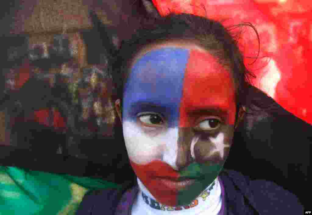 French and Kingdom of Libya flags are painted on the face of a protester during a demonstration in support of air strikes in Libya, in Benghazi. (Reuters)