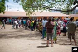 Residents of New Caledonia's capital, Noumea, wait in line at a polling station before casting their vote as part of an independence referendum, Nov. 4, 2018.