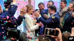 Ukrainian comedian and presidential candidate Volodymyr Zelenskiy, center right, and his wife Olena Zelenska, center left, greet their supporters at his headquarters in Kyiv, Ukraine, Sunday, April 21, 2019. 