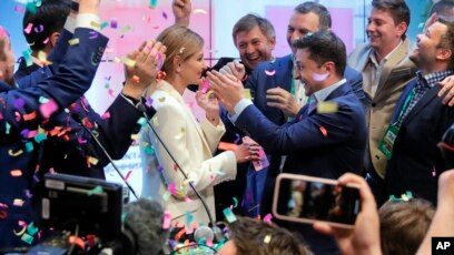 Ukrainian comedian and presidential candidate Volodymyr Zelenskiy, center right, and his wife Olena Zelenska, center left, greet their supporters at his headquarters in Kyiv, Ukraine, Sunday, April 21, 2019. 