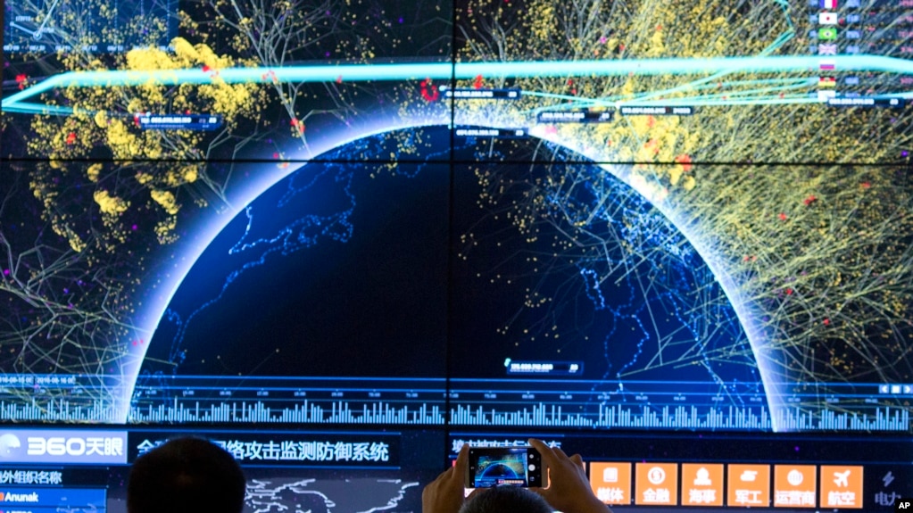 资料照 - 2016年8月16日在北京召开的第四届中国网络安全会议上，一位与会者正在用手机对全球网络攻击检测防御系统的视觉画面拍照。(photo:VOA)