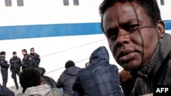 Migrants wait at the port of Lampedusa to board a ferry bound for Porto Empedocle in Sicily, Italy, Feb. 20, 2015. 