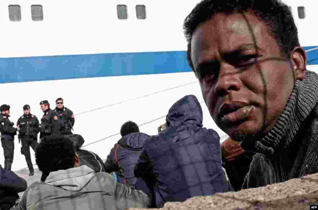 Para migran menunggu di pelabuhan Lampedusa untuk naik kapal feri menuju Porto Empedocle di Sisilia. Pihak berwenang di Pulau Lampedusa Italia berjuang untuk mengatasi masuknya banyak pendatang baru sementara sejumlah organisasi kemanusiaan memperingatkan dengan adanya krisis Libya itu berarti ribuan lebih migran baru kemungkinan akan datang ke wilayah itu. &nbsp;