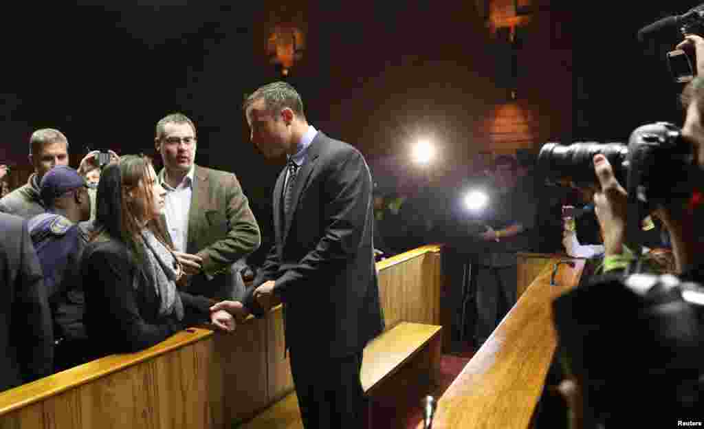Oscar Pistorius chats with his sister Aimee ahead of court proceedings at the Pretoria Magistrates court June 4, 2013.