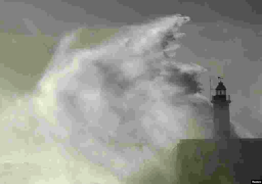 Waves crash against a lighthouse at Newhaven, southeast England, Oct. 28, 2013. 