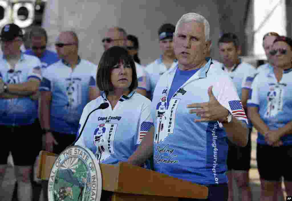 Gov. Mike Pence speaks as his wife Karen, looks on at the opening ceremony for the Cops Cycling for Survivors fundraising bike ride in Indianapolis, July 11, 2016.