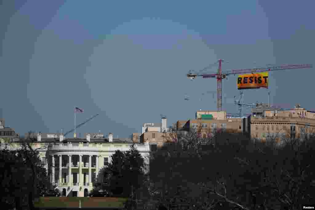 국제환경보호단체 그린피스 회원들이 미국 워싱턴 DC 백악관 인근 공사현장 크레인에 올라 &#39;저항하라&#39;라고 적힌 대형 현수막을 펼치고 있다.