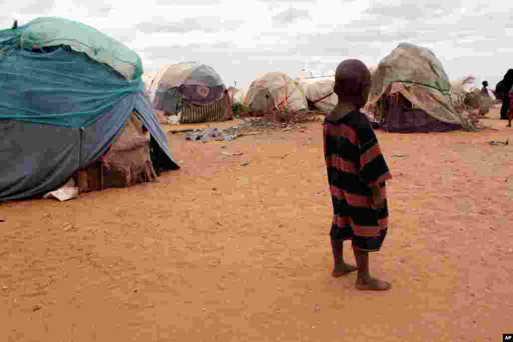 SOMALIA: A barefoot child stands among ragged tents at a refugee camp in Dolo, Somalia on Wednesday, July 18, 2012. The U.N., which declared a famine in Somalia one year ago, says conditions have improved but that 2.5 million people are still in crisis.