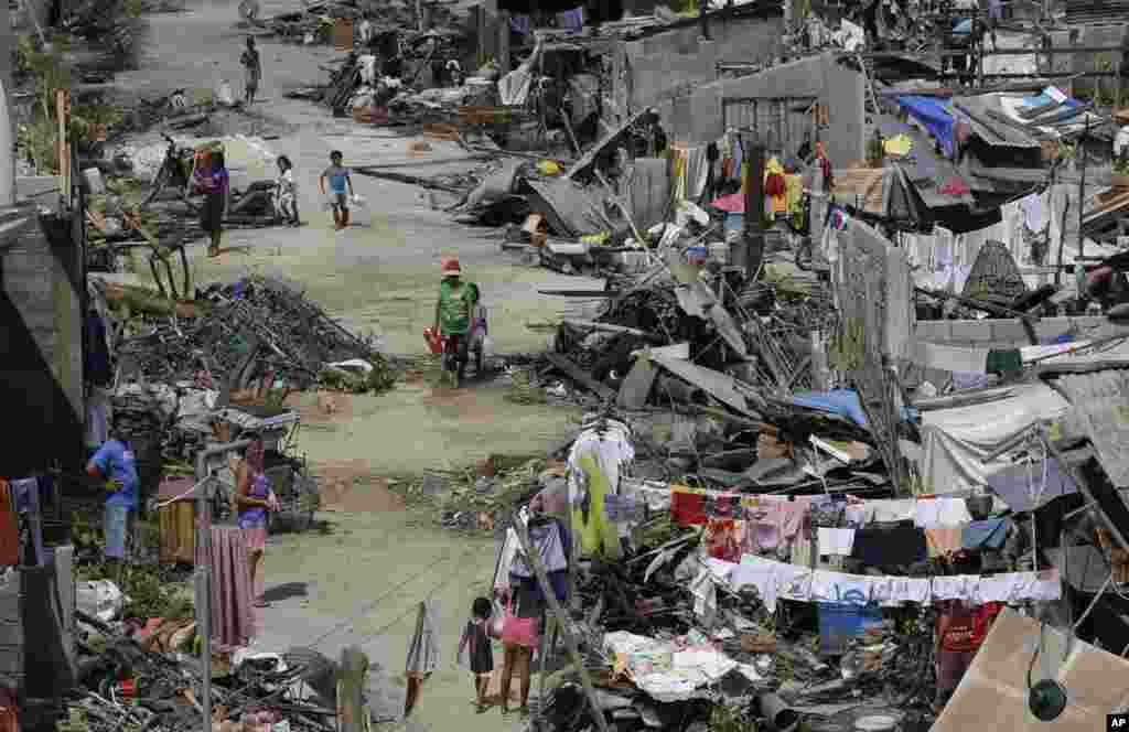 Survivors of Typhoon Haiyan walk amid ruins of their homes in Maraboth, Philippines, Nov. 14, 2013.&nbsp;