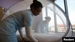 Nurses set up a mosquito tent over a hospital bed, as part of a precautionary protocol for patients who are infected by Zika at Farrer Park Hospital in Singapore Sept. 2, 2016