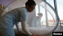 سنگاپور به تازگی به مناطقی که احتمال شیوع زیکا در آن وجود دارد، اضافه شده است و پرستاران روی تخت بیماران پشه بند نصب می کنند.