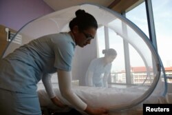 Nurses set up a mosquito tent over a hospital bed, as part of a precautionary protocol for patients who are infected by Zika at Farrer Park Hospital in Singapore Sept. 2, 2016