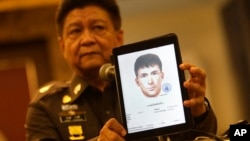 Police spokesman Lt. Gen. Prawuth Thavornsiri shows a photo of one of three men that Thai authorities have issued new arrest warrants in connection with the bombing case, bringing the total number of wanted suspects to seven during a press conference in Bangkok, Thailand, Tuesday, Sept. 1, 2015. Thai authorities arrested a man they believe is part of a group responsible for a deadly bombing at a shrine in central Bangkok two weeks ago, Prime Minister Prayuth Chan-ocha announced Tuesday. He said the suspect resembles a yellow-shirted man in a surveillance video who police say planted the bomb. (AP Photo/Sakchai Lalit) 