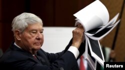 FILE - Former Senator Bob Graham (D-FL) displays 28 pages that are still classified and blacked out, of a U.S. government report on who financed the 9/11 attacks on the United States, at a news conference on Capitol Hill, July 5, 2015.