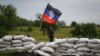 A pro-Russian activist regulates road traffic at a checkpoint outside the eastern Ukrainian city of Druzhkovka, June 2, 2014.