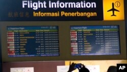 Seorang turis asing menggunakan telepon genggamnya untuk memotret papan informasi penerbangan yang menunjukkan informasi penerbangan di Bandara Internasional Ngurah Rai di Bali, Indonesia, Rabu, 29 November 2017.
