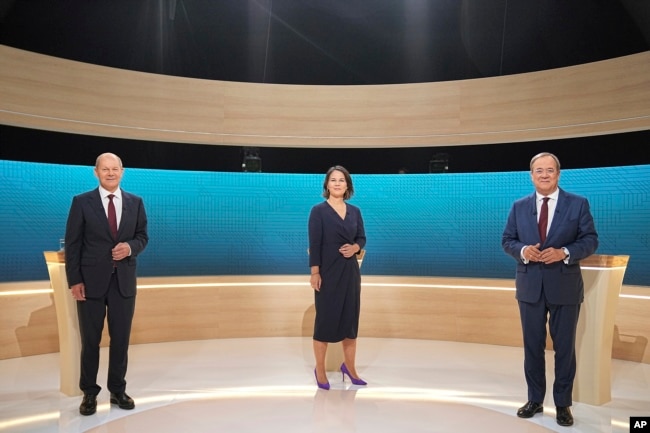 Kandidat rektor Olaf Scholz (SPD), Annalena Baerbock (Partai Hijau) dan Armin Laschet (CDU) berdiri di studio TV di Berlin, 12 September 2021. (Foto: AP)