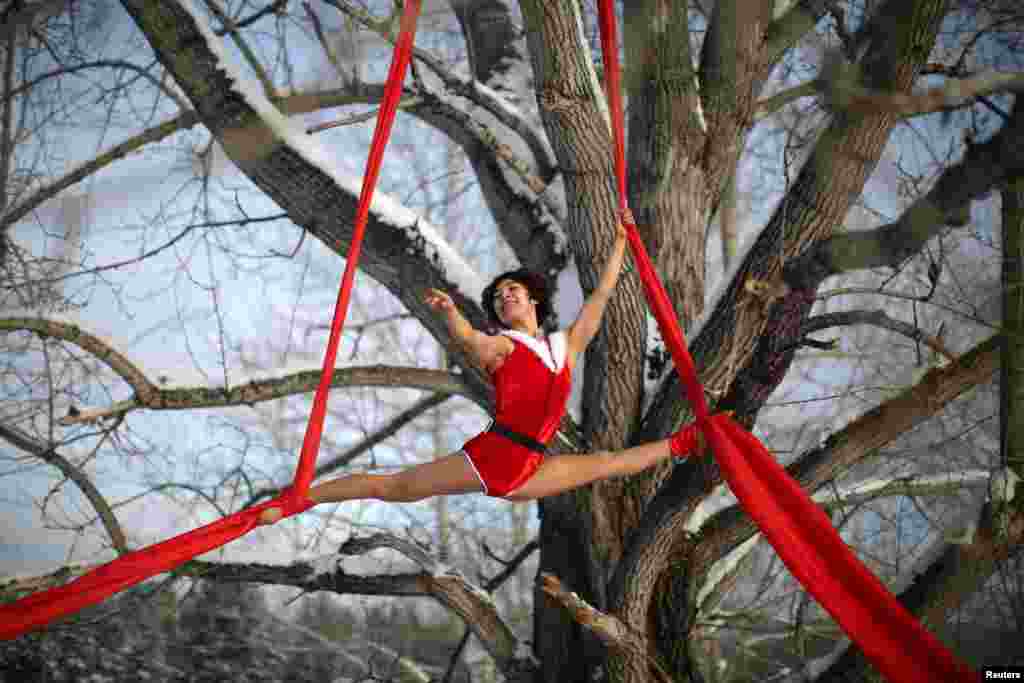 A dancer performs on a tree in temperatures below minus 37 degrees Celsius (minus 34.6 degrees Fahrenheit) in Mohe, Heilongjiang province, China.