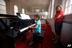 Vicky Chavez watches her daughter Yaretzi play on the piano in the chapel of the First Unitarian Church in Salt Lake City, Utah, May 31, 2018.