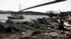 FILE - Backdropped by the Martyrs bridge over the Bosporus Strait, a man sits amongst the debris of the Reina nightclub that was attacked on New Year's Day, in Istanbul, May 22, 2017. Turkey's state-run news agency says authorities have partially destroyed the upscale Istanbul nightclub where an Islamic State group attacker killed 39 people. 