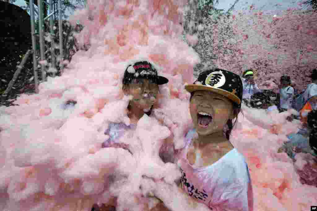 Children are engulfed by foam during the Bubble Show event in Beijing, China.